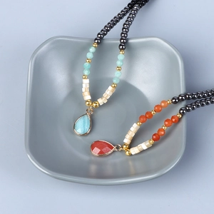 Detail van 4mm hematiet kralenkettingen met blauwe en oranje druppelvormige hangers