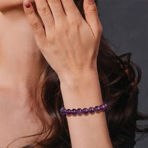 Pulsera de cuentas de amatista púrpura natural para hombre con modelo y fondo gris oscuro