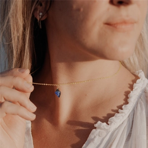 Lapis lazuli drop pendant necklace in gold finish worn on neck with white textured top