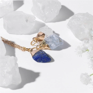Macro shot of irregular natural stone pendants and golden metal chain necklace set