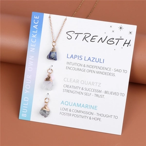 Close-up of raw stone pendant necklaces including Lapis and Quartz on display card