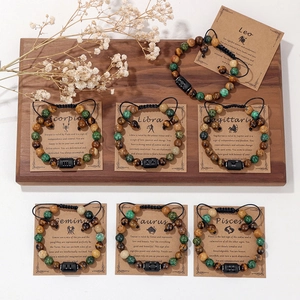 Braccialetti con perline zodiacali in pietre naturali e cordini regolabili su legno