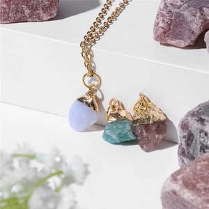 Minimalist gold necklace set with irregular natural raw stone pendants on display