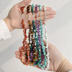 Gros plan de colliers en perles de pierre naturelle avec œil de tigre et malachite