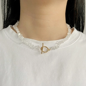 Macro shot of natural clear crystal chip necklace with gold OT toggle clasp on a model