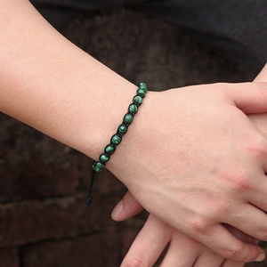Dettaglio di perline di malachite verde da 6mm su un bracciale intrecciato regolabile