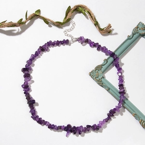 Collier en pierres violettes irrégulières avec fermoir argenté sur fond blanc épuré