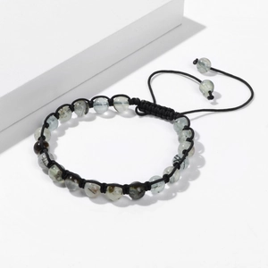 Dettaglio di perle di pietra da 6mm con cordino intrecciato nero regolabile su base bianca
