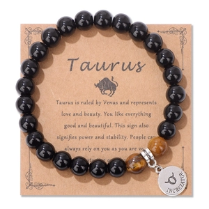 Detalle de la pulsera zodiaco Tauro con piedras ojo de tigre y colgante grabado