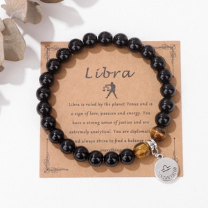 Detalle de la pulsera Libra con cuentas negras, piedras ojo de tigre y colgante de plata