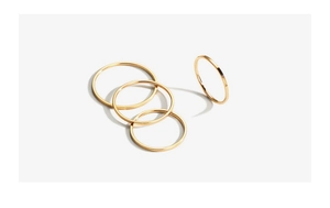 Macro shot of a four-piece set of minimalist 18k gold plated stainless steel thin rings