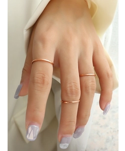 Detailed close-up of three minimalist thin stackable rings in polished rose gold finish