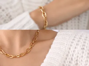 Close-up of golden coffee bean link chain necklace worn over white knitted sweater