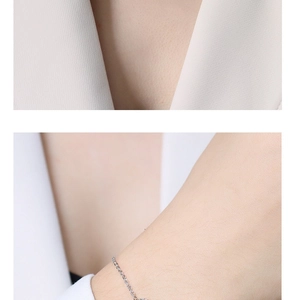 Dettaglio del bracciale e della collana minimalisti in argento indossati con tailleur