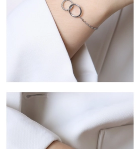 Dettaglio macro del bracciale in argento con doppi anelli intrecciati lisci e ritorti