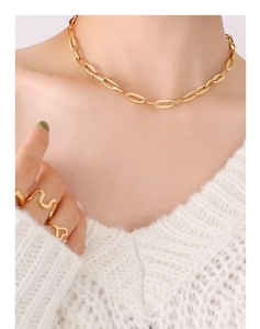 Detailed view of 18K gold plated paperclip chain necklace and elegant rings on a model