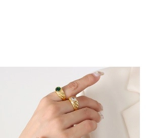 Detail of vintage gold-plated rings with emerald green and clear zircon oval stones