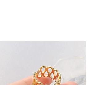 Close-up of a hollow teardrop design gold ring with minimalist geometric pattern