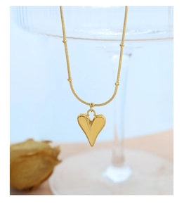 Detailed macro view of an 18K gold-plated heart pendant on a delicate snake chain