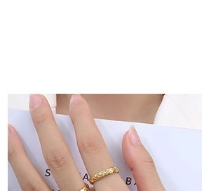 Dettaglio anello dorato con design trapuntato di lusso sulla mano di una modella