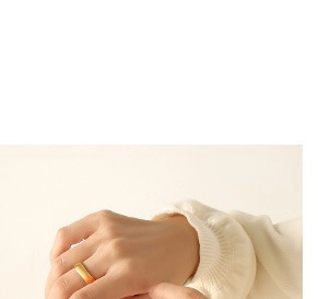 Primo piano di un anello a fascia piatta dorato minimalista con manica in maglia