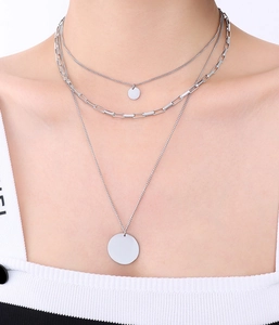 Detail van de drielaagse zilveren ketting met paperclip-schakels en ronde hangers