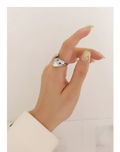 Detailopname van een zilveren minimalistische ring met vloeiend ontwerp aan vrouwenvinger