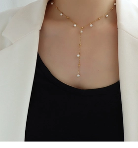 Vue détaillée du collier français en Y doré avec pendentifs de perles blanches
