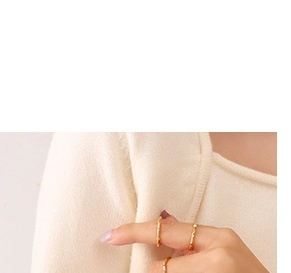 Detail of three stackable 18K gold-plated rings featuring a minimalist bamboo texture design