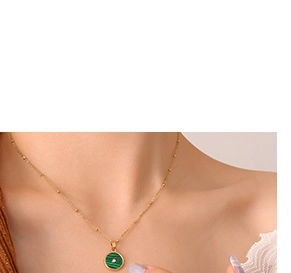 Gros plan d'un collier en chaîne dorée avec pendentif rond en pierre de malachite
