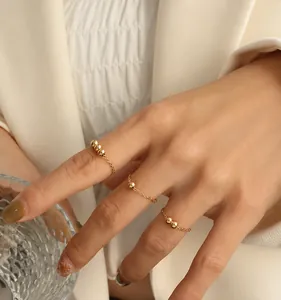 Detailweergave van minimalistische 18k vergulde kettingringen met kleine parels