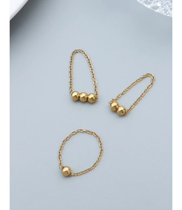 Vue détaillée de trois bagues chaînes minimalistes en or 18 carats avec de petites billes