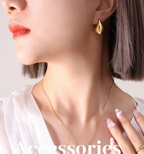 Gros plan d'un ensemble collier et boucles d'oreilles en or 18 carats sur un mannequin