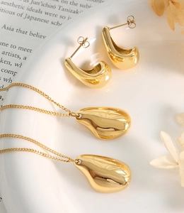 Détail de l'ensemble collier et boucles d'oreilles dorés 18 carats en forme de goutte