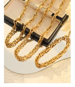 Vue détaillée d'un collier à grosse chaîne dorée tressée avec un fermoir mousqueton solide