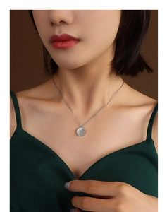 Close-up of white rose mother-of-pearl pendant on a silver chain worn by a female model