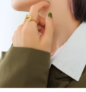 Close-up of a 18K gold plated C-shaped ring with twisted rope detail worn by a model