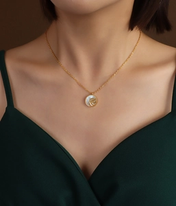 Detailed close-up of a white rose zircon necklace on a model wearing a green dress