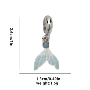 Detailed view of silver mermaid tail pendant with blue enamel and small gemstone