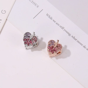 Makroansicht von blattförmigen Anhängern mit rosa Strasssteinen in Silber und Roségold