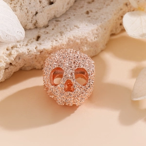 Détail macro d'une perle crâne en or rose pour bijoux DIY avec texture de micro-gravure fine