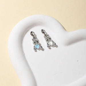 Macro view of silver rabbit pendants with heart stones in a white ceramic dish