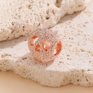 Détail d'une perle tête de mort creuse or rose avec surface texturée pour bijoux DIY