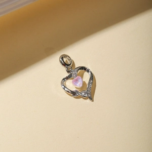 Macro shot of silver hollow double heart pendant with pink stone and small cubic zirconia