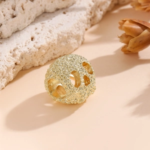 Détail macro de perles d'espacement dorées ajourées avec texture mate pour bijoux DIY