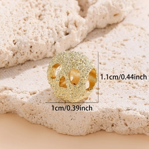 Détail d'une perle tête de mort dorée creuse pour bijoux DIY montrant 1,1 cm de hauteur et taille