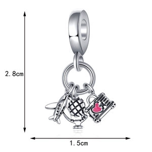 Detail view of silver travel charm with airplane, globe, and pink heart suitcase charms