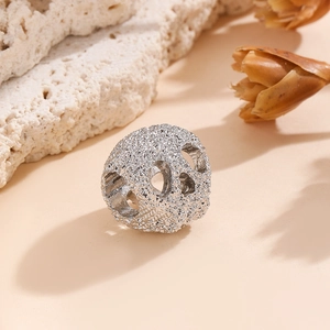 Macro d'une perle tête de mort argentée avec découpes circulaires pour bijoux DIY