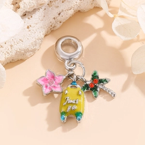 Tropical travel charms with yellow suitcase, pink flower and green palm tree on silver base