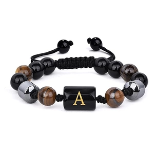 Détail du bracelet en œil de tigre avec perle lettre A et cordon tressé ajustable